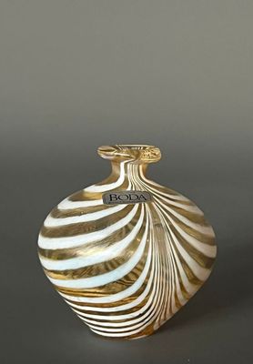 un vase blanc et doré posé sur une table