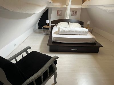 une chambre avec un lit et une chaise
