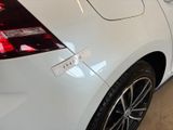the rear end of a white car with a sticker on it