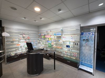 an image of a pharmacy office with a desk and refrigerator