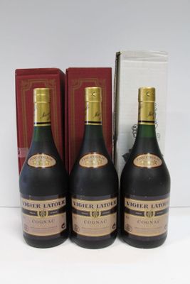 trois bouteilles d'alcool posées sur une table, à côté d'une boîte de livres