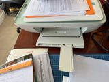 a printer sitting on top of a desk next to a pile of papers