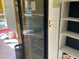 a glass door refrigerator in the middle of a room