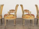 four chairs with upholstered back and arms are sitting on a wooden floor
