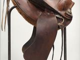 a saddle that is sitting on a stand in a room