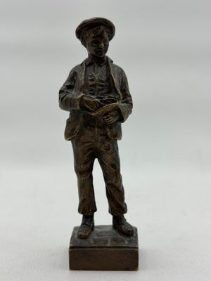 figurine en bronze représentant un homme portant un chapeau et tenant un livre
