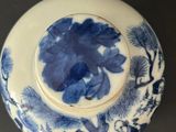 a blue and white plate with a blue flower on it