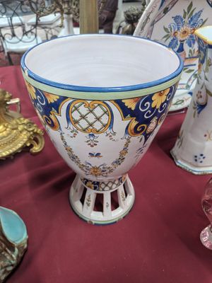 un grand bol posé sur une table, à côté d'autres vases