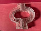 un cendrier en verre transparent posé sur un tissu rouge