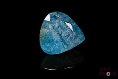 a close up of a blue stone on a black surface