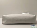 an empty white purse sitting on top of a white table