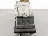 a statue of a person laying on a cart