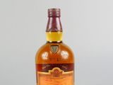une bouteille de whisky posée sur une surface blanche