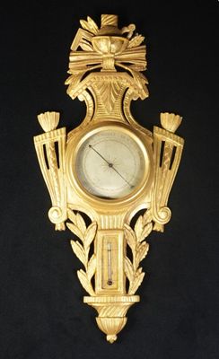 une horloge en or sur le mur avec un oiseau dessus