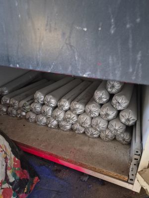 de nombreux rouleaux de tissu posés sur une étagère dans une pièce