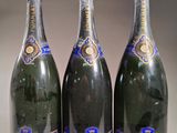 trois bouteilles de champagne posées les unes à côté des autres sur une table