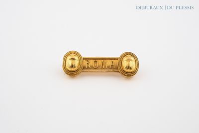a close up of a gold pin with the word roma on it