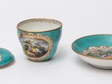 three cups and a saucer on a white surface