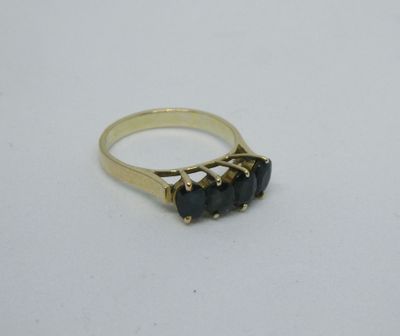 une bague en or ornée de trois pierres noires