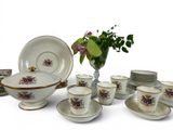 a lot of plates and cups and a vase with flowers
