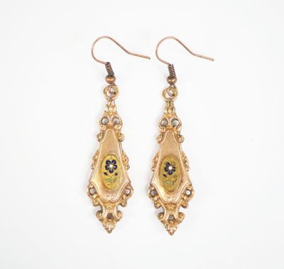 une image représentant une paire de boucles d'oreilles dorées ornées de fleurs