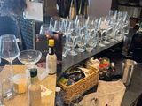 bottles of wine and glasses on a table with a basket on it