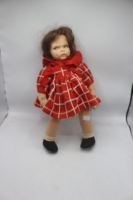une poupée en robe rouge sur fond blanc