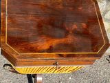 a small table with a wooden top on a stone ground