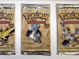 three packs of pokemon trading cards on a white surface