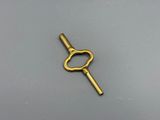 a gold key with a heart shaped handle on a gray surface