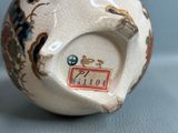 a white vase with a design on it sitting on a table