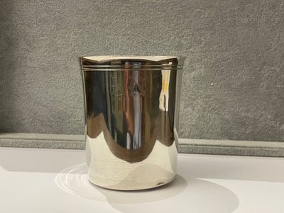 une coupe en argent posée sur une table blanche