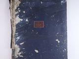 an old book with a red label on it sitting on a white surface
