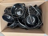 une boîte en carton remplie d'un tas de casseroles et poêles noires