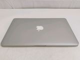 a silver apple laptop sitting on a white surface