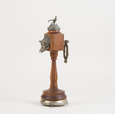 une image représentant un objet en bois et en métal sur lequel figure un oiseau