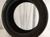 a close up of a tire on a white surface with a curtain in the background
