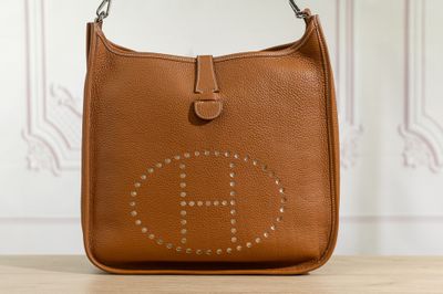 sac à main en cuir marron avec un logo riveté sur le devant