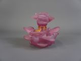 une petite bougie rose posée sur une table