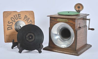 une petite boîte en bois sur laquelle est posé un disque, à côté d'une vieille radio