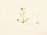a small gold anchor with a white pearl on it
