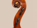 a close up of the back of a violin with a fiddle in the foreground