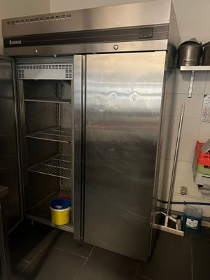 a stainless steel refrigerator in a kitchen next to a counter