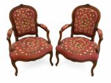 paire de fauteuils en noyer sculpté de style Louis XV, recouverts de tissu rouge