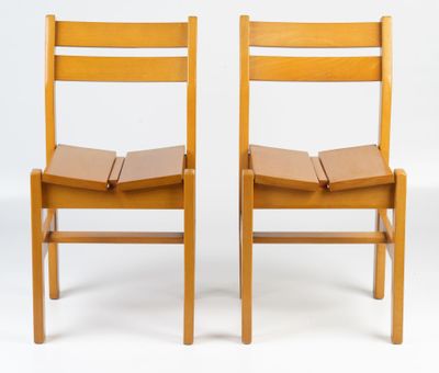 two wooden chairs sitting next to each other on a white surface