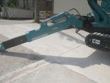 an image of a small excavator parked in a parking lot