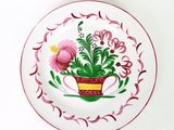 une assiette sur laquelle est représentée une fleur dans un pot