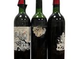 trois bouteilles de vin sont posées les unes à côté des autres sur une surface blanche