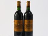 deux bouteilles de vin rouge posées l'une à côté de l'autre sur une surface blanche