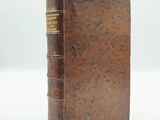 an old book sitting on top of a white surface